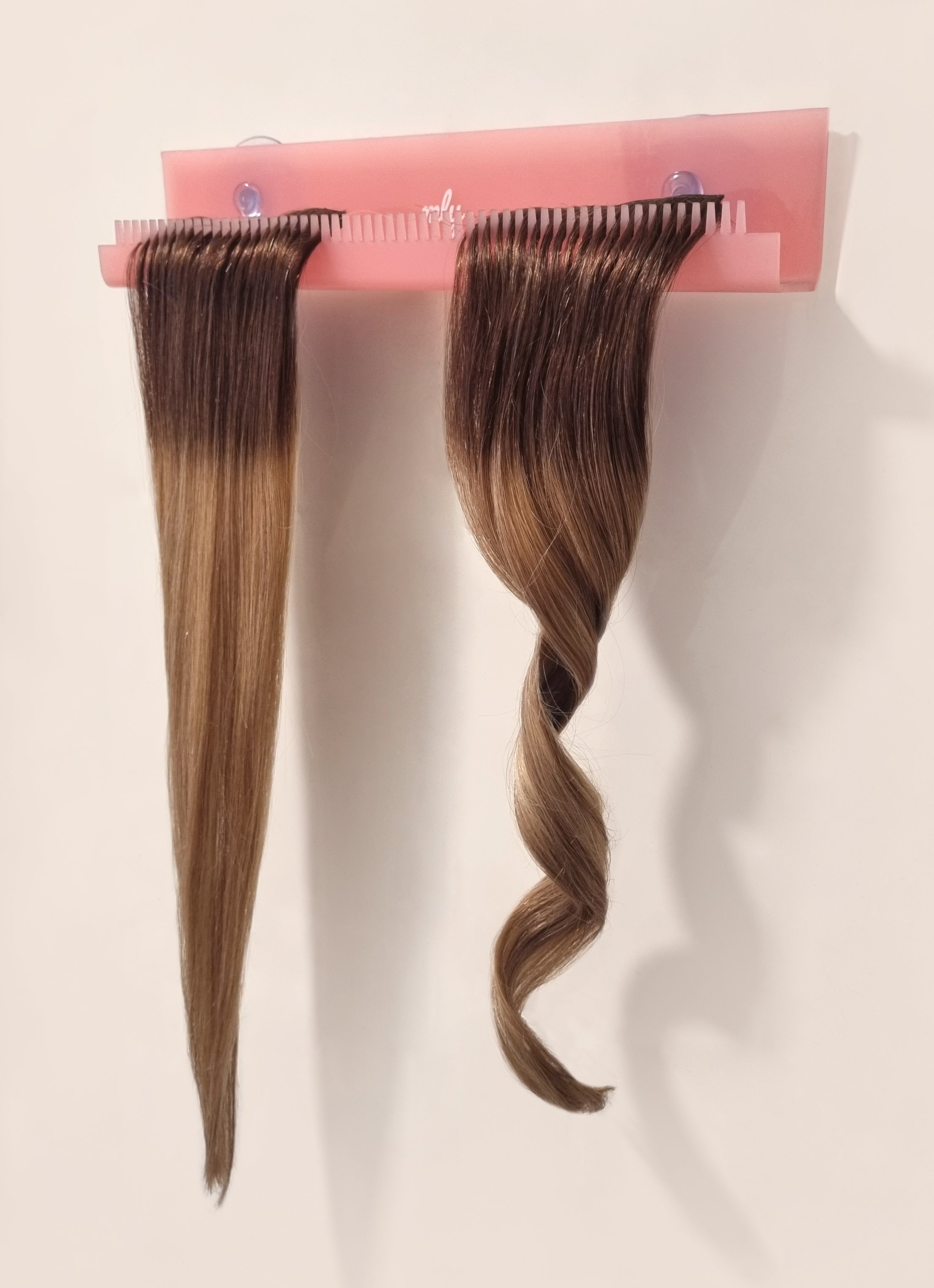 Roze hairextensions styler, kunststof hanger met tandjes om je haar vast te houden. 