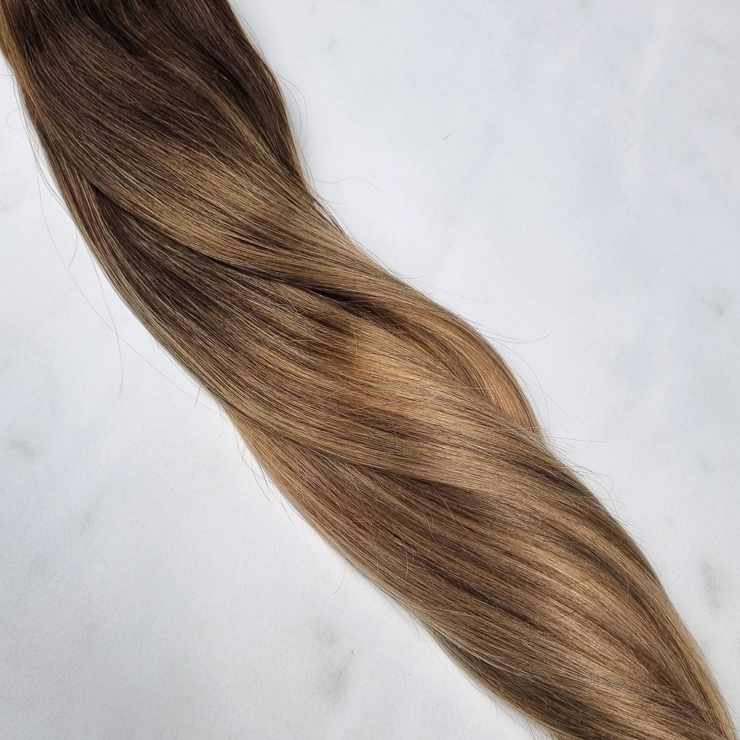 Balayage clip in hairextensions met een donkere aanzet en midden blonde punten.